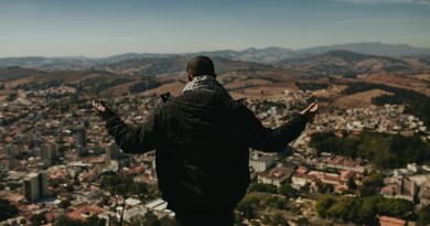 a man standing on top of a lush green hillside