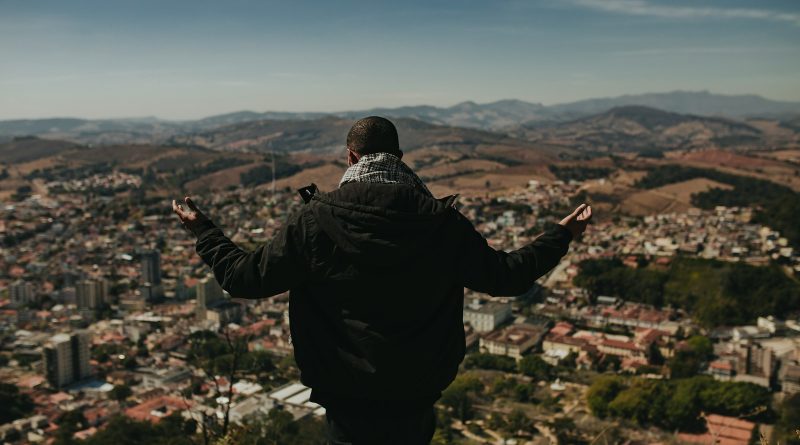 a man standing on top of a lush green hillside