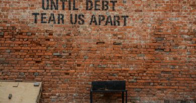 Until debt tear us apart printed red brick wall at daytime